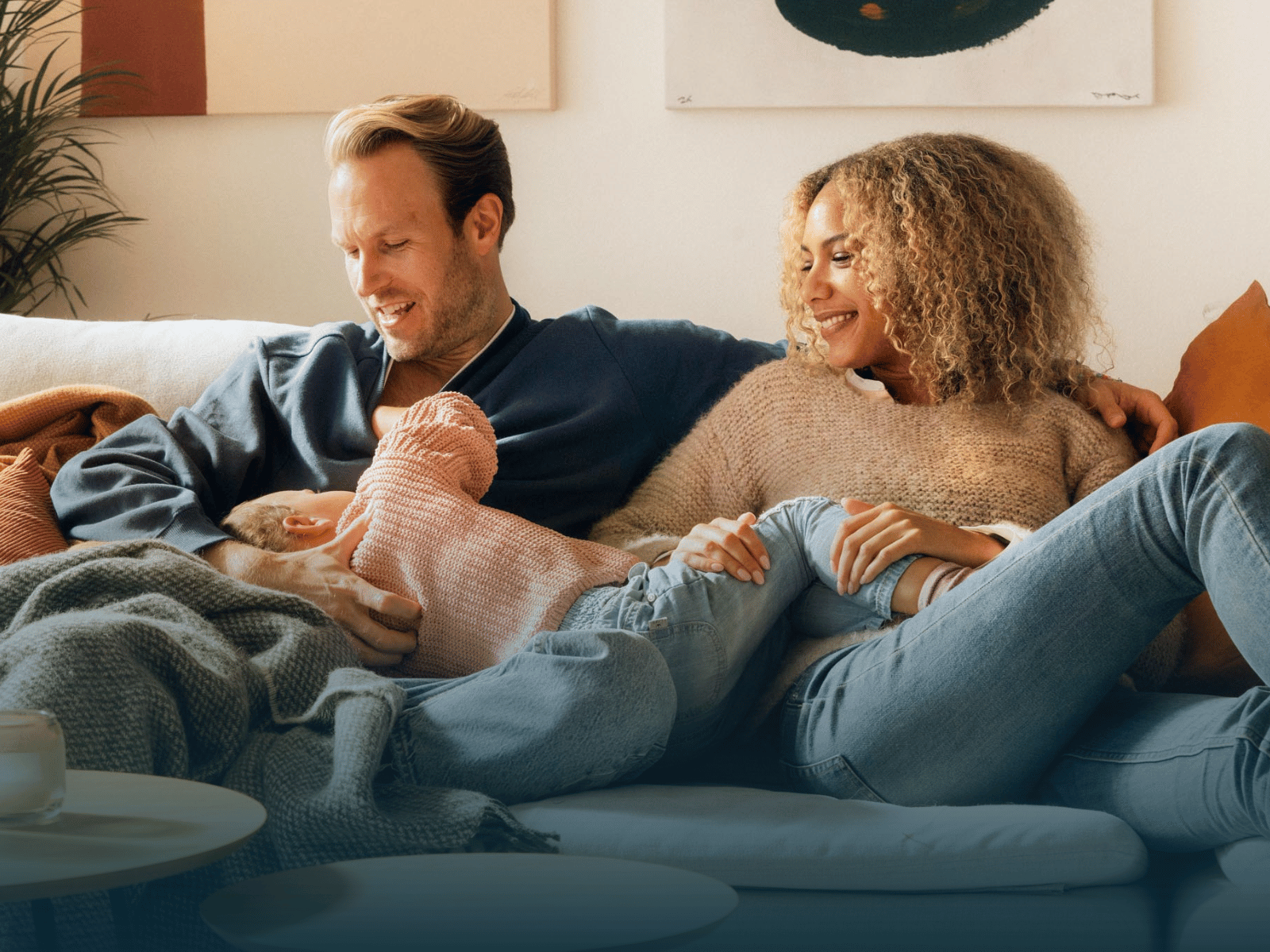 Familie på tre som sitter i sofaen